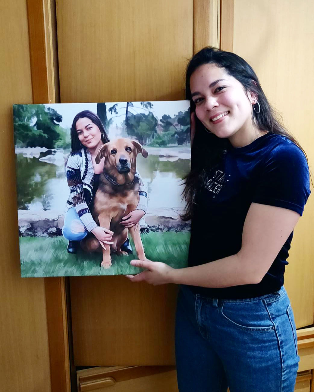Una chica sujetando su retrato personalizado en lienzo en el que sale con su mascota, un perro
